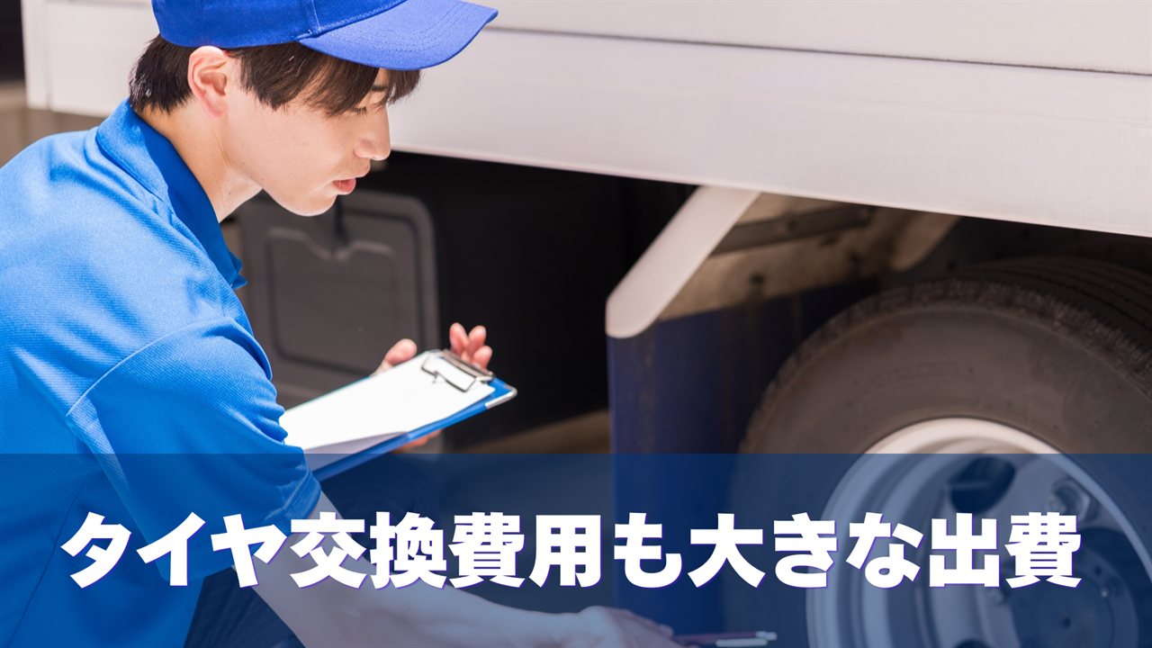 トラックのタイヤを点検する作業者